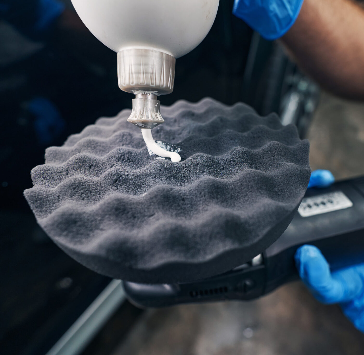 Person covering car polishing pad with cream
