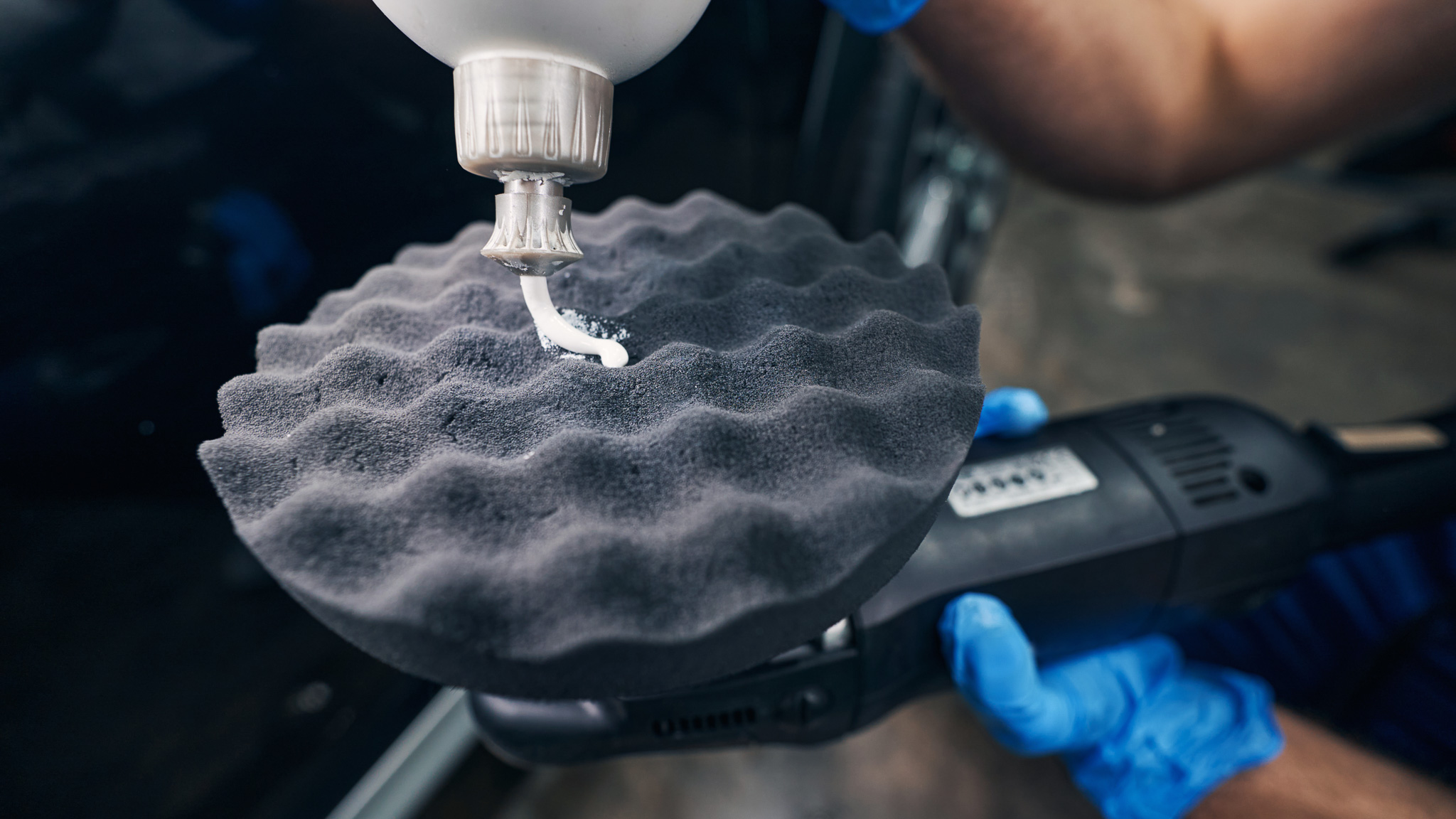 Person covering car polishing pad with cream